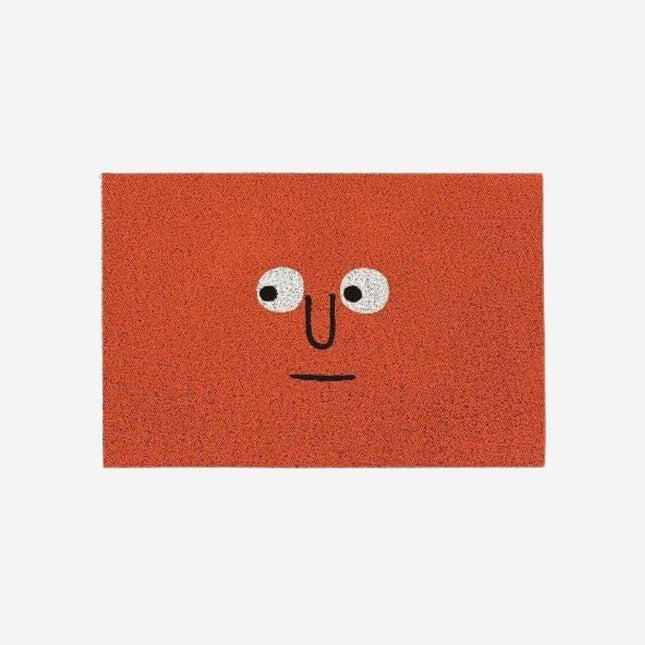 Červená rohožka s vtipným obličejem