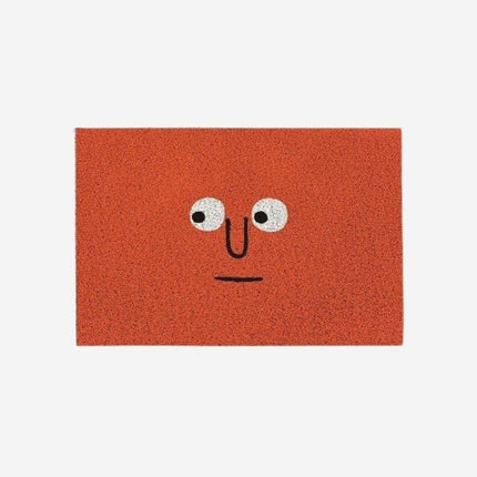 Červená rohožka s vtipným obličejem