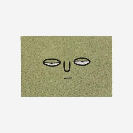 Zelená rohožka s vtipným obličejem