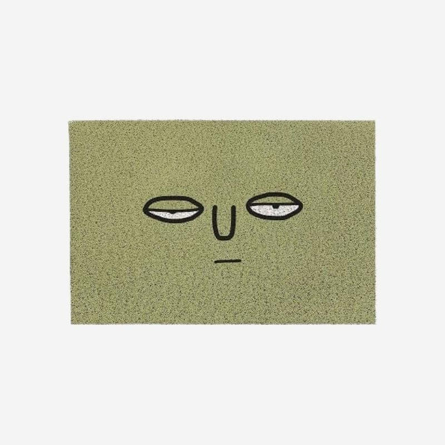 Zelená rohožka s vtipným obličejem