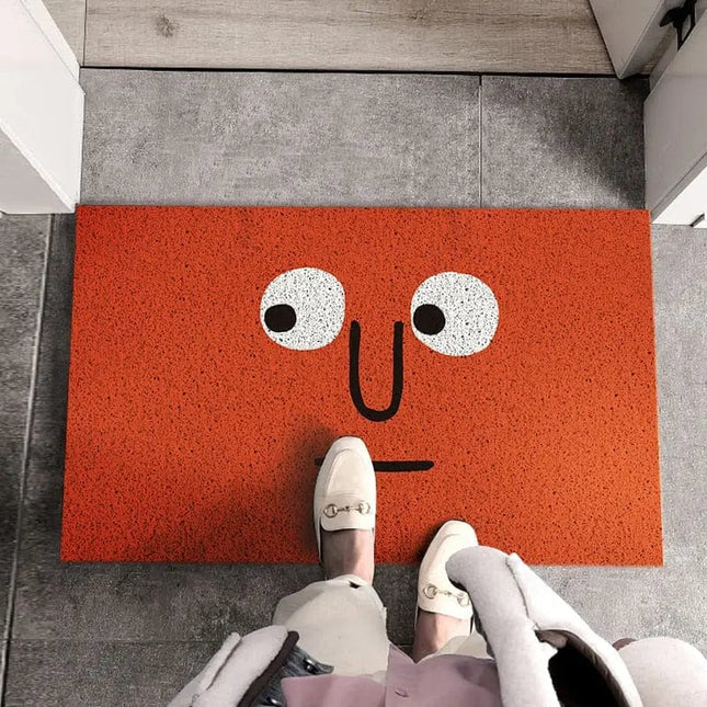 Červená rohožka s vtipným obličejem
